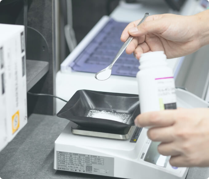 薬の量を測る薬剤師